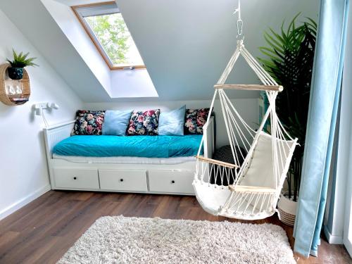 a swing in a room with a blue couch at Bohemian Eco lodge át lake Balaton in Kisapáti