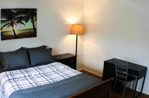 a bedroom with a bed and a desk and a lamp at Urban Oasis - 3BR 2BA - City View- Private Parking in Pittsburgh