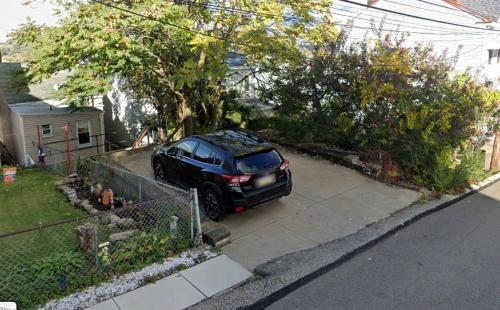 a black car parked in a driveway at Urban Oasis - 3BR 2BA - City View- Private Parking in Pittsburgh