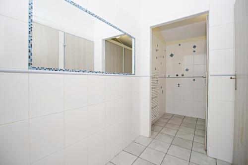 een witte badkamer met een inloopdouche en een spiegel bij Hostel Cinnamon in Krakau