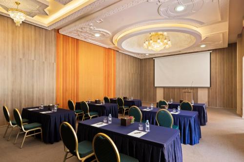 a conference room with tables and chairs and a projection screen at Savoy Le Grand Hotel Marrakech in Marrakech
