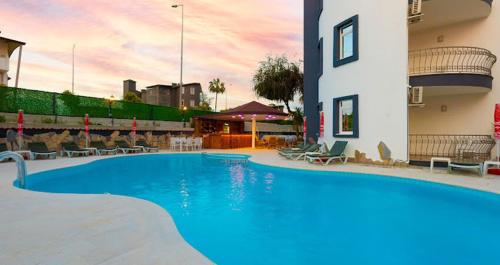 a large blue swimming pool next to a building at MERYAM SÜİT DELUXE in Side