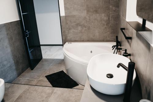 a bathroom with a white sink and a bath tub at Greta Apartments in Taranto