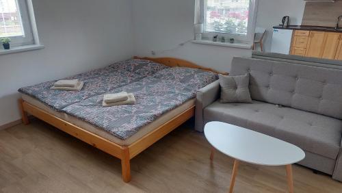 a small bedroom with a bed and a couch at Chalupa Synka in Terchová