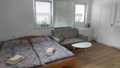 ein Schlafzimmer mit einem Bett, einem Sofa und einem Tisch in der Unterkunft Chalupa Synka in Terchová