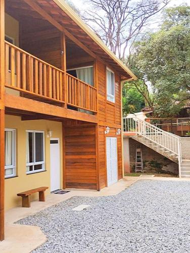 a wooden house with a staircase and a porch at VIA SPE - Pousada in Belo Horizonte
