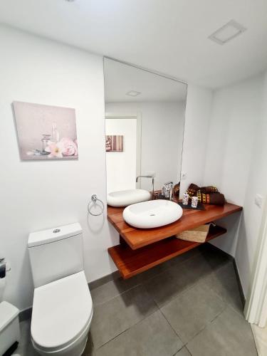 a bathroom with a toilet and a sink and a mirror at Vita Ideale in Arguineguín