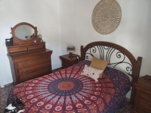 a bedroom with a bed with a red blanket and a mirror at Apartamento en Serra con preciosas vistas. in Serra
