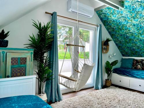 um quarto com uma cama de baloiço e uma janela em Bohemian Eco lodge át lake Balaton em Kisapáti