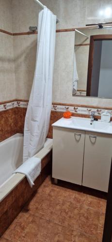La salle de bains est pourvue d'une baignoire, d'un lavabo et d'une douche. dans l'établissement Piso al lado de la playa, à Boiro