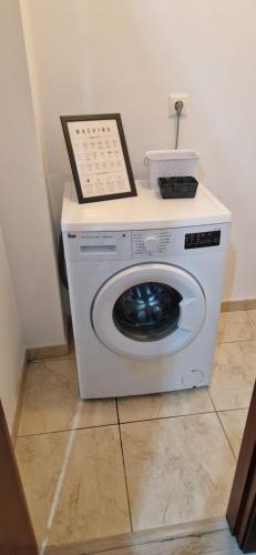 a washer and dryer with a picture on top of it at Piso al lado de la playa in Boiro