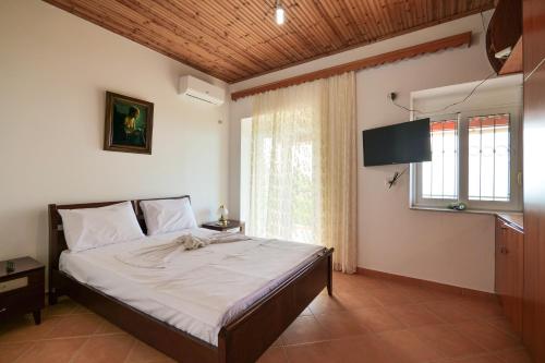 a bedroom with a bed and a large window at Gurra room's in Lukovë