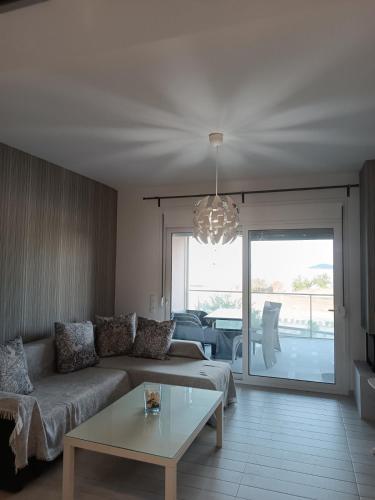a living room with a couch and a table at Peramos View Luxury Maisonette in Nea Peramos