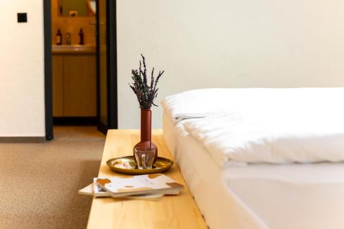 a vase on a table next to a bed at VILLA BASAMAK in Sarajevo