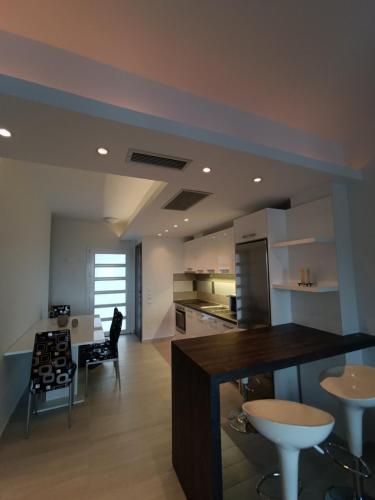 a kitchen with a counter and chairs in a room at Peramos View Luxury Maisonette in Nea Peramos