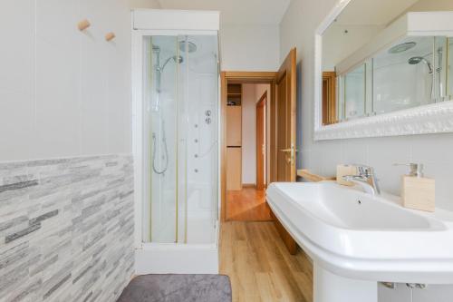 bagno bianco con lavandino e doccia di MarcoPoloAirport-3 Camere da letto-Wifi-Netflix-15' da Venezia a Tessera