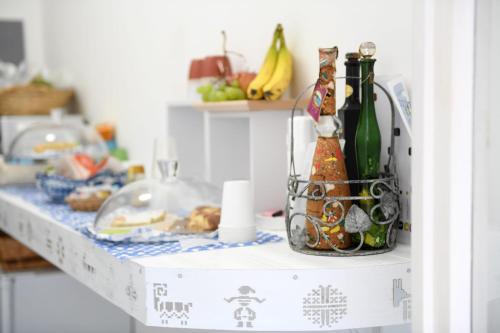 una mesa con botellas de vino y un plato de comida en ALGHERO NOON, en Alghero