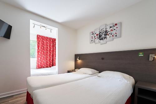 a bedroom with two beds and a window at Authentic by balladins Dijon / Marsannay-la-Côte in Marsannay-la-Côte
