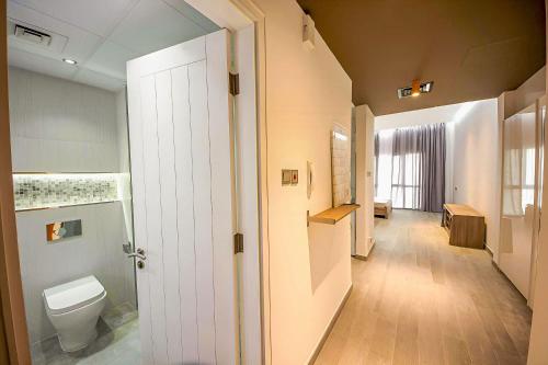 a bathroom with a toilet and a hallway at Upgraded studio close to Metro in Dubai