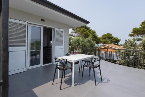 un patio con tavolo e sedie su un balcone di Sweet Sicily Apartments a Carini