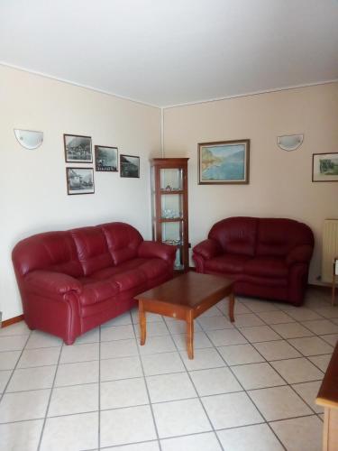 a living room with two red couches and a coffee table at La Casa sul Lago Apartments - Olive Tree Apartment in Limone sul Garda