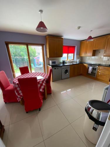 eine Küche mit roten Stühlen und einem Tisch darin in der Unterkunft Beach Close Lodge in Kinsale
