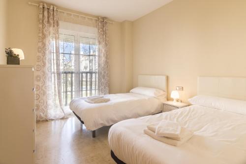 1 dormitorio con 2 camas y ventana en 2197-Superb 2bedrooms in residence with pool!, en Manilva