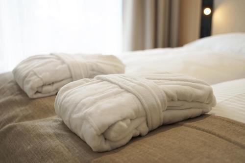 two white towels sitting on top of a bed at Hotel Linea Mare in Pobierowo