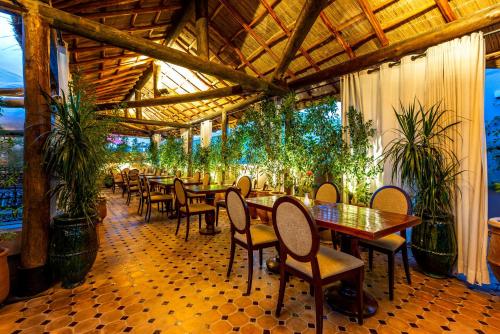 Palais Tara & Spa في مراكش: مطعم بالطاولات والكراسي والنباتات