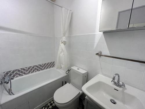 une salle de bain blanche avec des toilettes et un lavabo dans l'établissement Appartement rénové aux Gets, proche pistes et lac, avec parking, navettes gratuites et accepte animaux - FR-1-623-266, aux Gets