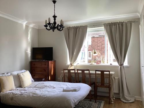 Schlafzimmer mit einem Bett, einem Tisch und einem Fenster in der Unterkunft Lexus House 10mins- Durham Uni & Heritage Coast 