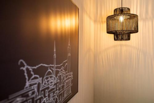 a chandelier hanging from a wall with a picture at VILLA BASAMAK in Sarajevo