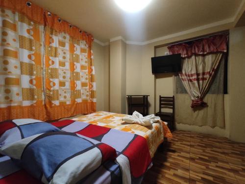 a bedroom with a bed and a television in it at Hotel hospedaje Odonovan in Tacna