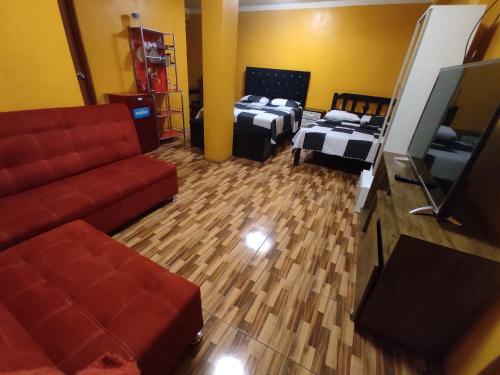 sala de estar con 2 camas y sofá en Hotel hospedaje Odonovan, en Tacna