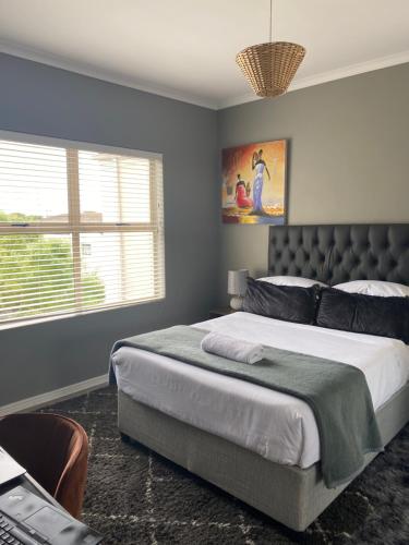 Un dormitorio con una cama grande y una ventana en The CoziPlace en Ciudad del Cabo