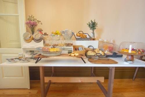 a white table with a bunch of food on it at Dom José Alojamentos by Guestify in Guimarães