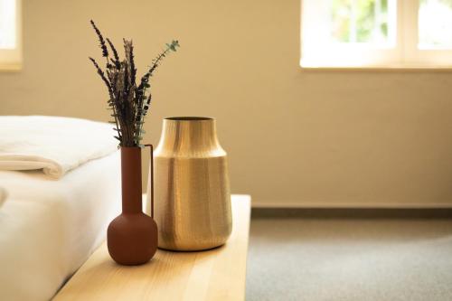 two vases sitting on a table next to a bed at VILLA BASAMAK in Sarajevo