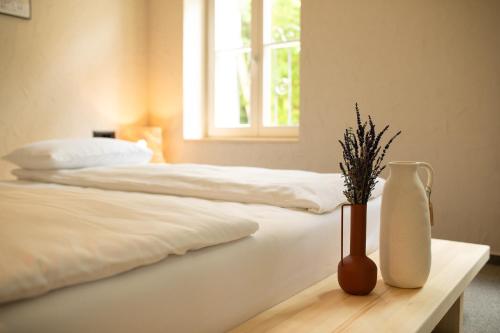 a bedroom with two beds and a vase on a table at VILLA BASAMAK in Sarajevo