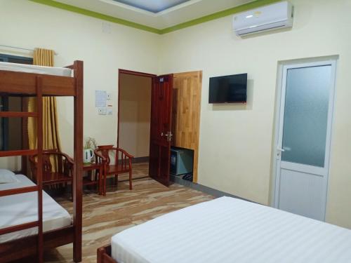 a bedroom with two bunk beds and a tv at Đức Chính Hotel - Ninh Chu - Phan Rang in Phan Rang