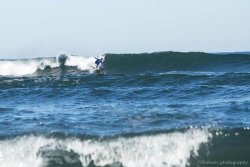 a person riding a wave on a surfboard in the ocean at Cabañas Borde Lindo in Valdivia