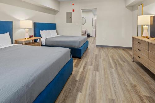 a hotel room with two beds and a dresser at Seaport Suites in Wildwood