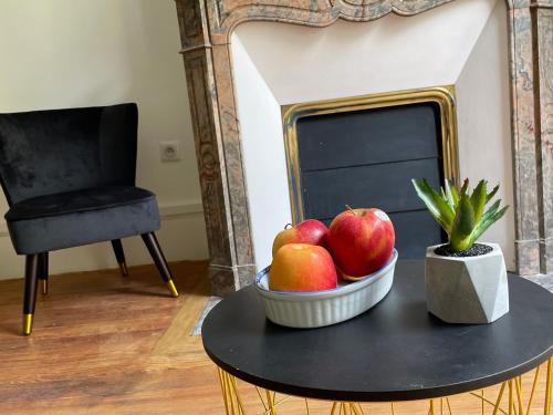 uma tigela de maçãs numa mesa em frente a uma lareira em Charmant Studio beaux volumes #1 em Dreux