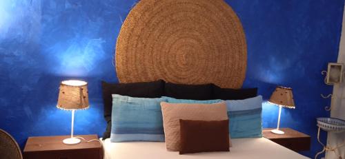 a bedroom with blue walls and a bed with two lamps at Casinha Amarela in Montargil
