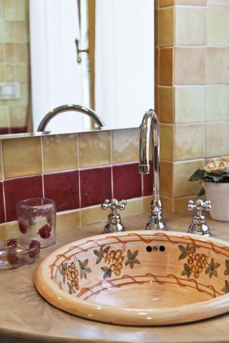 a bathroom sink with a wooden plate on a counter at Marchesi Incisa Winery Lodge in Rocchetta Tanaro