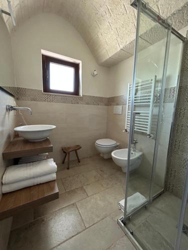 ein Bad mit einer Dusche, einem Waschbecken und einem WC in der Unterkunft Agli Antichi Trulli B&B In Masseria in Alberobello