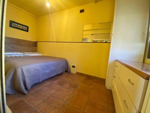 een slaapkamer met een bed en een gele muur bij La Vecchia Bottega in Montorio