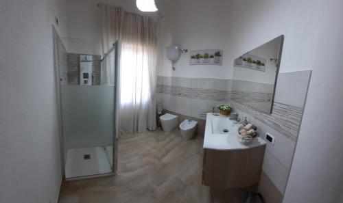 een badkamer met een wastafel, een douche en een spiegel bij Holiday Home Dolia Center in Dolianova
