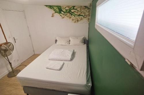 a small bed in a room with a window at Ciel de Paris in Paris