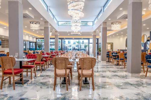 a dining hall with tables and chairs and chandeliers at Saint Star Kemer - Adult Only in Kemer