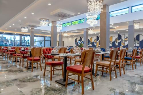 a dining hall with tables and chairs and chandeliers at Saint Star Kemer - Adult Only in Kemer